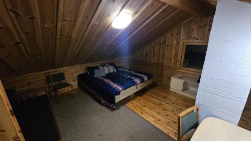a bedroom with a bed in a wooden cabin at Authentic Finnish Lakeside Cottage in Lusila