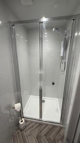 a shower with a glass door in a bathroom at Anglebury House in Wareham
