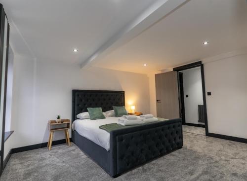 a bedroom with a large bed with a black headboard at Rose House in Boston