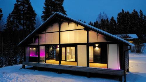 a small house in the snow at night at Villa Taipale - 10hlö, Himosranta in Jämsä