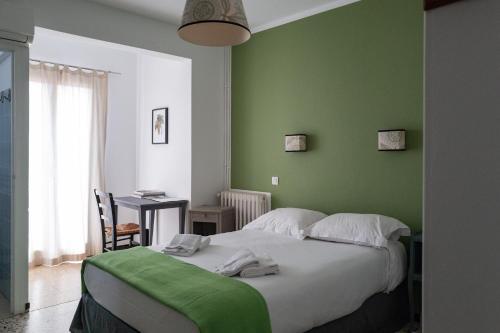 a bedroom with green walls and a bed with towels on it at Chez Marie in Linguizzetta