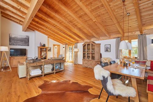 a living room with a wooden ceiling and a table at Landhauswohnung Dosbach in Reit im Winkl