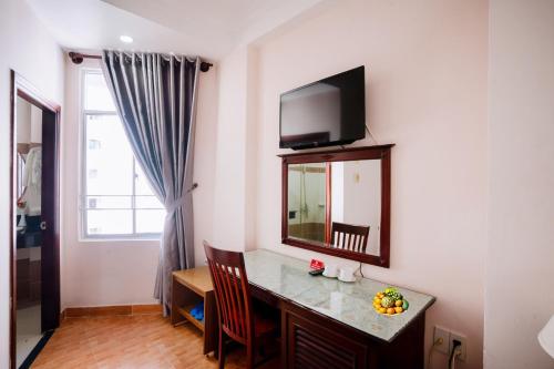a room with a desk with a mirror and a television at Violet hotel&spa in Nha Trang