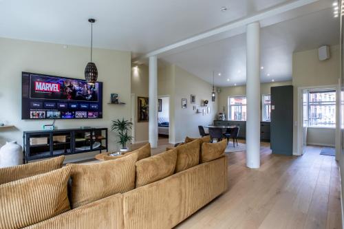 a living room with a couch and a flat screen tv at Ved Amagerbanen in Copenhagen