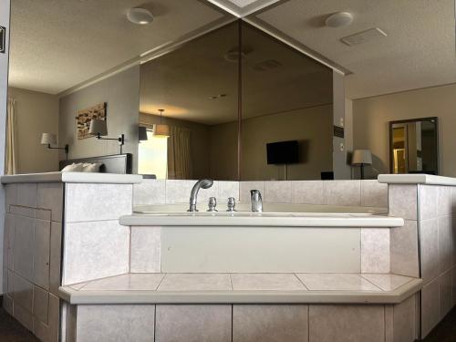 a large bathroom with a tub and a large mirror at Companion Hotel Motel in Hearst