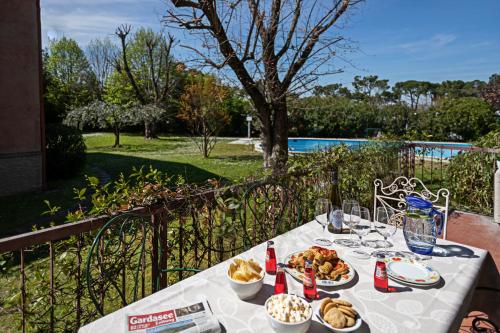 a table with plates of food and drinks on it at EDDA - Regarda Travel in Lazise