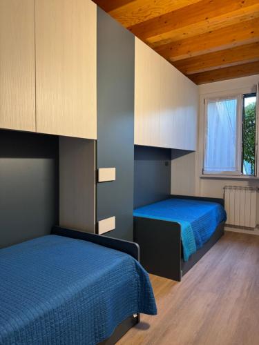 a bedroom with two beds and a window at La Casa di Lella in Paratico