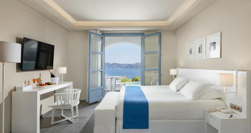 a bedroom with a bed and a view of the water at Acroterra Rosa Luxury Suites & Spa in Akrotiri