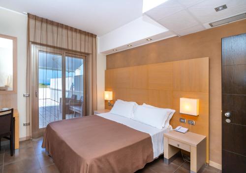 a hotel room with a large bed and a desk at Abruzzo Marina Hotel - Family & Beach Resort in Silvi Marina