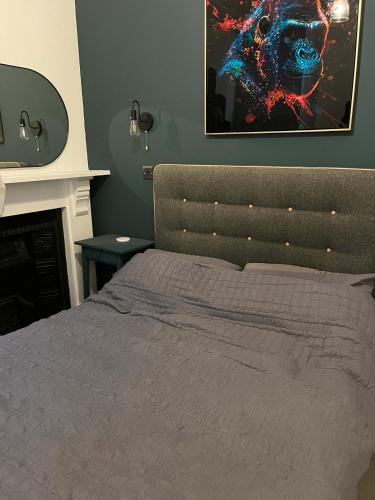 a bedroom with a bed and a picture on the wall at Stylish 2Bed Ground Floor Flat with Private Garden in Weston-super-Mare