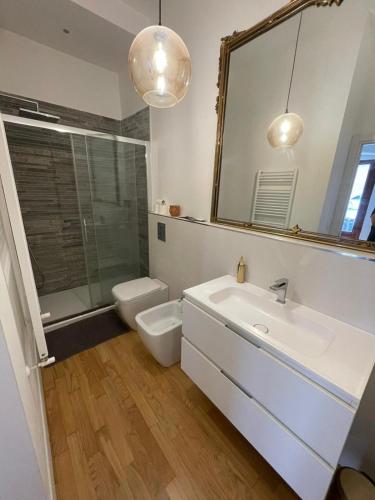 a bathroom with a sink and a toilet and a mirror at Guiscardo Suites in Bari