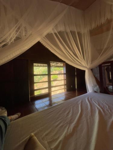 a bed with a white canopy in a room at Căn gentle home in Da Lat