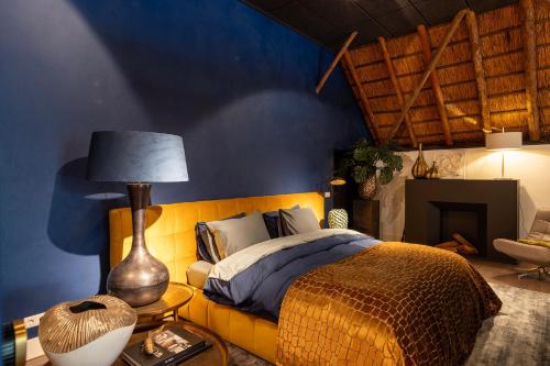 a bedroom with a bed and a table with a lamp at Luxe Veluwse Bosrand Suite met Jacuzzi en Zwembad in Lunteren