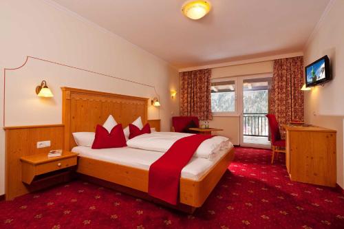 a hotel room with a large bed and a television at Alp Resort Tiroler Adler in Sölden