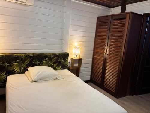 ein Schlafzimmer mit einem Bett mit einem weißen Kissen darauf in der Unterkunft Waki lodge in Cayenne