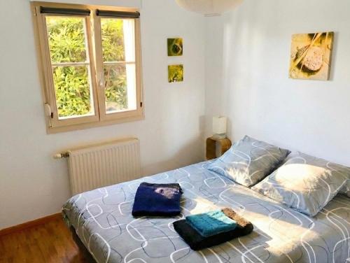 a bedroom with a bed with two bags on it at Le Grasberg in Bergheim