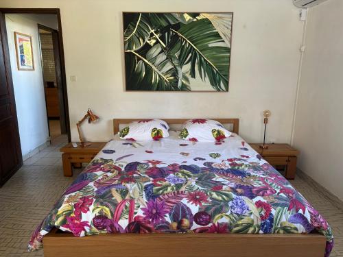 a bedroom with a bed with a colorful blanket at Le jardin des B-joux - Piscine privée - 3 ch et 3 sdb indépendantes - Grand jardin arboré - Vue mer et Pitons du Carbet - 10 mn de la plage - Propriété fermée - Aucun vis à vis in Le Morne-Vert