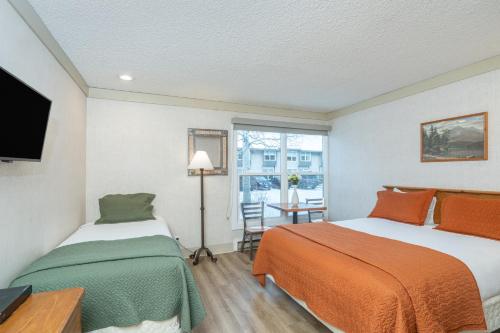 two beds in a room with a window at Mountainside Inn 320 by Alpine Lodging Telluride in Telluride