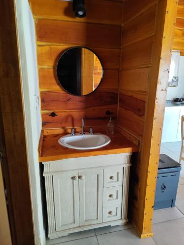 a bathroom with a sink and a mirror at Los Grillos Cabañas Serranas in Los Reartes