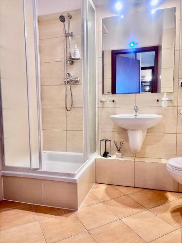 a bathroom with a shower and a sink at Apartament Nad Parsętą in Kołobrzeg