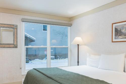 a bedroom with a bed and a window at Mountainside Inn 202 by Alpine Lodging Telluride in Telluride