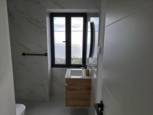 a bathroom with a sink and a window at Casa Rosinha, views & sunset in Calheta