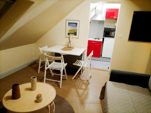 un soggiorno con tavolo e sedie e una cucina di Le Saint Georges a Chinon