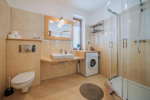 a bathroom with a sink and a washing machine at WHY NOT Apartament Krywań in Kościelisko
