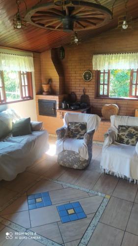 a living room with two beds and two chairs at Chacára Reni in Itajubá
