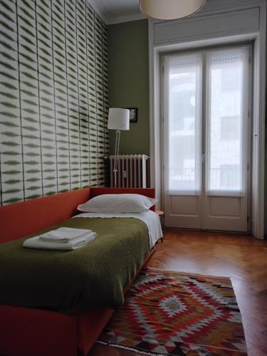 a bedroom with a bed and a large window at Casatitta Bed & Breakfast in Milan