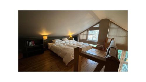 a bedroom with a bed with white sheets and a window at Chambre d'Hôtes Les Augustins - Parking sécurisé - Borne de recharge in Huy