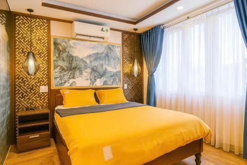 a bedroom with a yellow bed and a painting on the wall at Lagoon Homestay Hoi An in Hoi An