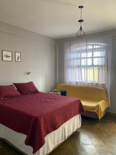 a bedroom with a large bed and a window at Flat na beira da praia in Maricá