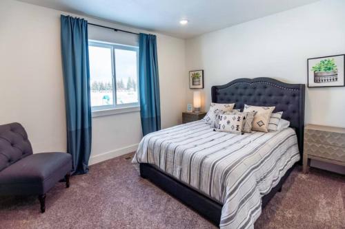 a bedroom with a bed and a chair and a window at Lulu’s Family Lakehouse in Garden City