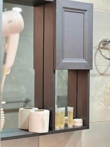 a bathroom with a shelf with towels and a mirror at Golden Stars Luxury Camp Wadi Rum in Wadi Rum