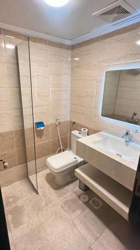 a bathroom with a toilet and a sink and a mirror at فندق بارك برايم - Park Prime Hotel in Mecca