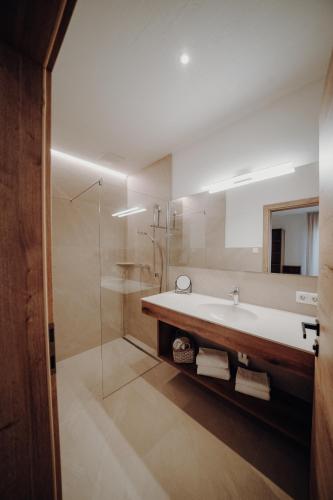 a bathroom with a tub and a sink and a shower at Kleinberg Chalet in Filzmoos