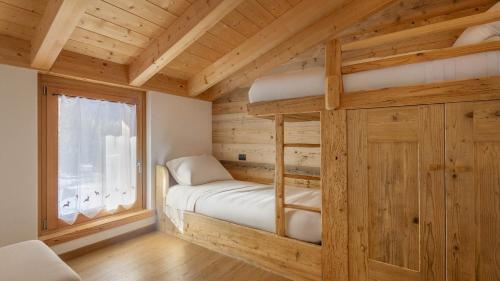 a bedroom with a bunk bed in a log cabin at Chalet Les Combes in Ponte di Legno