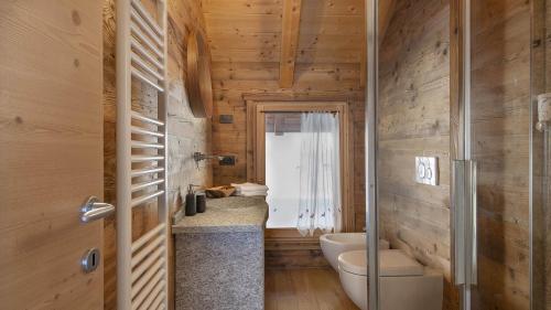 a bathroom with a toilet and a sink at Chalet Les Combes in Ponte di Legno
