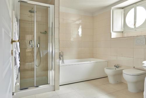 a bathroom with a tub and a toilet and a shower at Villa Royal in Florence