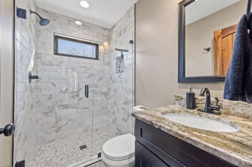 a bathroom with a shower and a sink and a toilet at Anchor Point- Hot Tub, Firepit, Ping Pong in Rogers