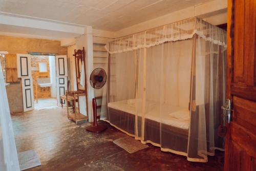 a bedroom with a canopy bed in a room at Villa de Zoysa Yoga, Wellness & Waves in Busse