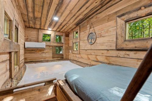 a bedroom in a log cabin with a bed in it at Amazonia- Pet Friendly, Firepit, Outdoor Shower in Pine Ridge