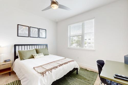 a white bedroom with a bed and a desk at 2 Mi to UF Campus! Modern Luxury Apt w/ Pool in West Hills