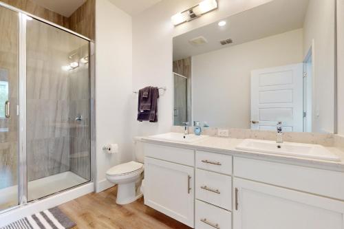 a bathroom with a toilet and a sink and a shower at 2 Mi to UF Campus! Modern Luxury Apt w/ Pool in West Hills