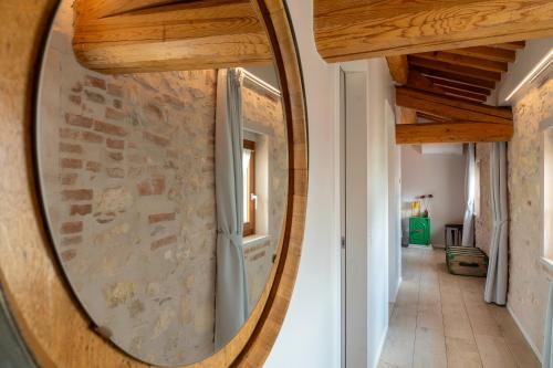 a round mirror on a wall in a hallway at Magari Estates Boutique Hotel in Colognola ai Colli