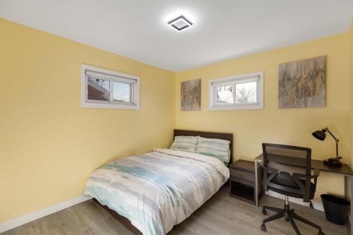 a bedroom with a bed and a desk and two windows at Furnished Private Room in a Spacious Shared Home#3 in Norton
