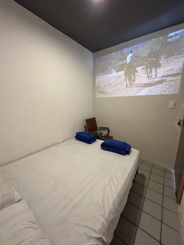 a bedroom with a bed with blue pillows on it at Mini Suite Sossego in Garanhuns