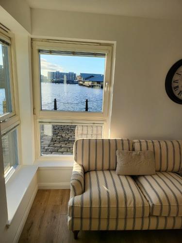 a living room with a couch and a large window at Quayside Waters in Dundee