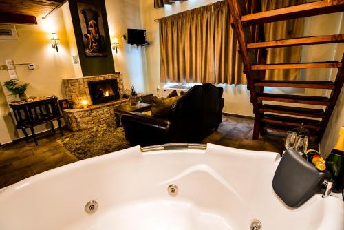 a bath tub in a living room with a fireplace at Camelia Suites in Synikia Mesi Trikalon